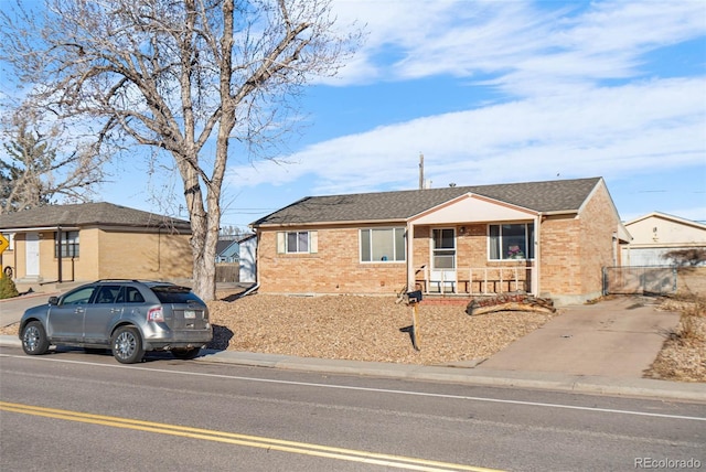 single story home featuring brick siding and a shingled roof