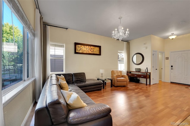 living room featuring a wealth of natural light, light hardwood / wood-style flooring, and a notable chandelier