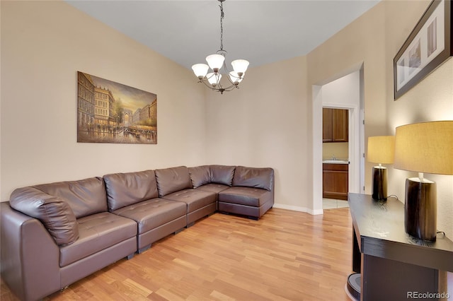 living room featuring a chandelier and light wood-type flooring