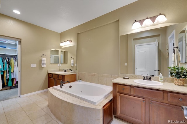 bathroom featuring vanity, tile patterned floors, and tiled tub