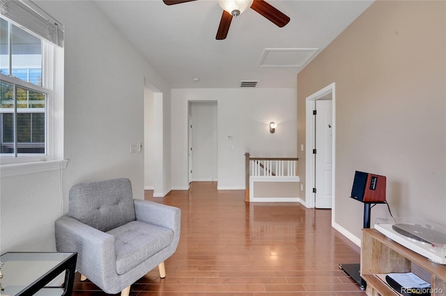 sitting room with hardwood / wood-style flooring and ceiling fan