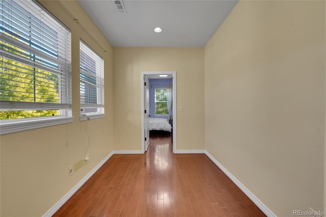 spare room featuring wood-type flooring and plenty of natural light