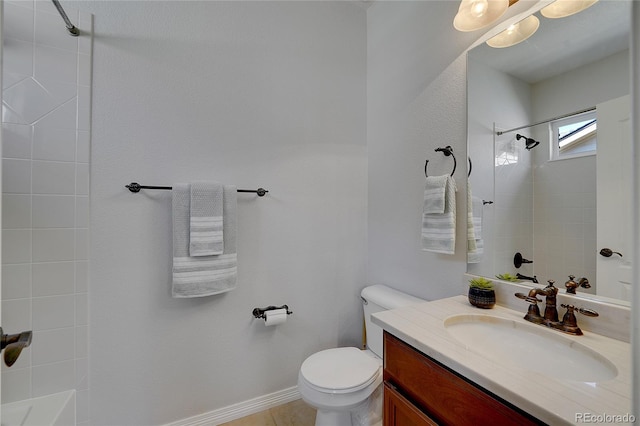 bathroom featuring tiled shower, vanity, toilet, and tile patterned flooring