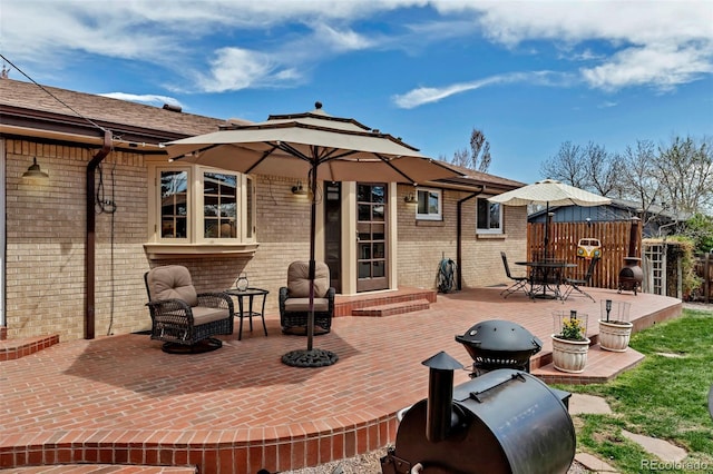 back of house featuring brick siding, a wooden deck, and outdoor dining area