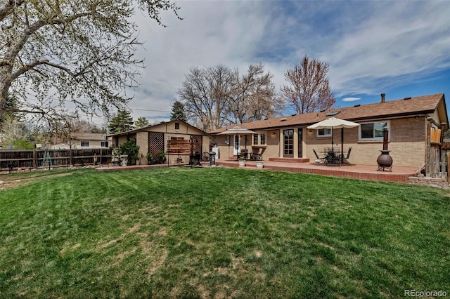 back of house featuring brick siding and a patio area