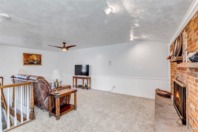 living room with a brick fireplace, carpet floors, vaulted ceiling, and a ceiling fan