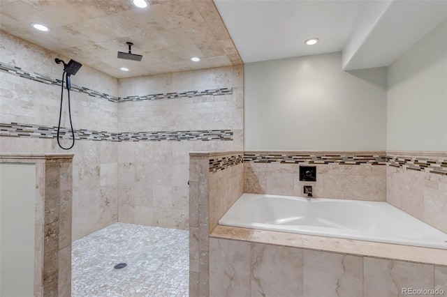 bathroom featuring recessed lighting, a garden tub, and a tile shower