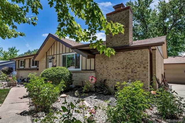 3630 W Saratoga Ave, Littleton, CO 80123 - view of front of property with a chimney, board and batten siding, brick siding, a garage, and a shingled roof