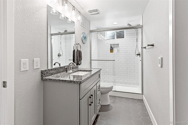 12256 W 34th Pl, Wheat Ridge, CO 80033 - bathroom featuring a textured wall, toilet, tile patterned floors, vanity, and a shower stall