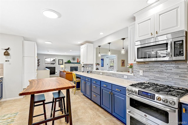 12256 W 34th Pl, Wheat Ridge, CO 80033 - kitchen with appliances with stainless steel finishes, blue cabinets, decorative backsplash, a stone fireplace, and white cabinets