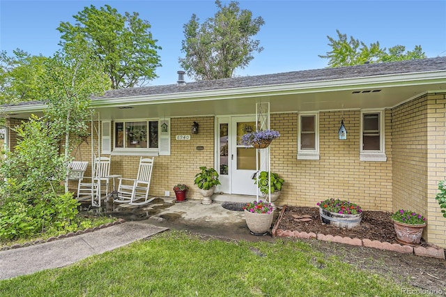 6940 W 63rd Ave, Arvada, CO 80003 - ranch-style house featuring brick siding, a porch, and a shingled roof