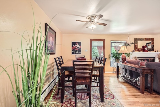 6940 W 63rd Ave, Arvada, CO 80003 - dining room with wood finished floors, ceiling fan, and baseboard heating