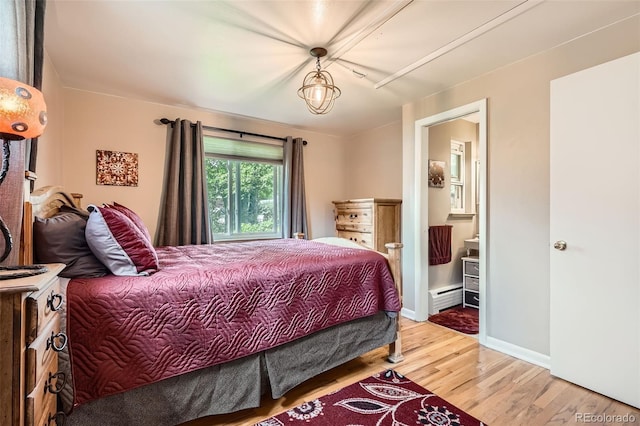 6940 W 63rd Ave, Arvada, CO 80003 - bedroom featuring a baseboard radiator, wood finished floors, and ensuite bathroom