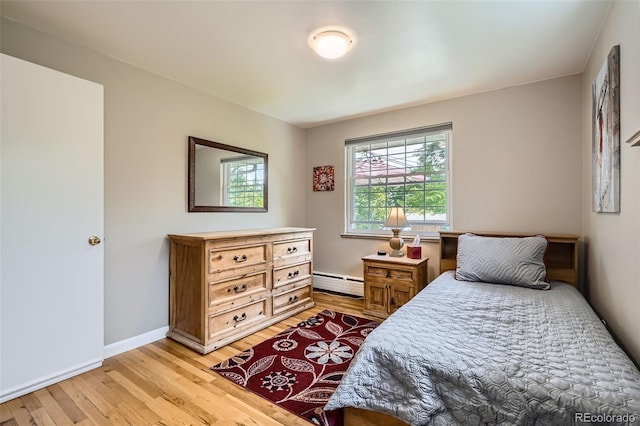 6940 W 63rd Ave, Arvada, CO 80003 - bedroom featuring a baseboard radiator and light wood-style floors