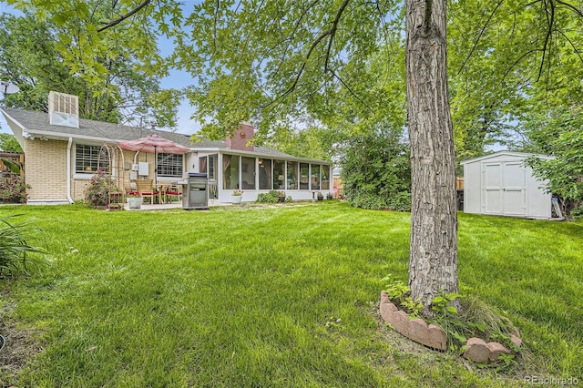 6940 W 63rd Ave, Arvada, CO 80003 - back of house featuring a sunroom, a shed, a lawn, a patio area, and brick siding