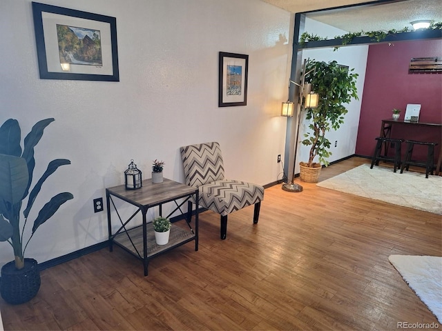 sitting room with wood-type flooring