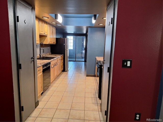 kitchen with light brown cabinetry, black dishwasher, sink, and light tile patterned floors