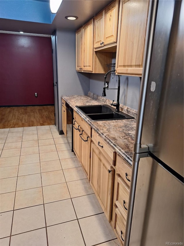 3550 S Harlan St Unit 313, Denver, CO 80235 - kitchen featuring freestanding refrigerator, a sink, black dishwasher, light brown cabinets, and light tile patterned flooring