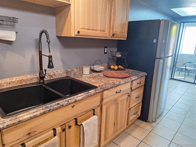 kitchen with light brown cabinetry, sink, light tile patterned flooring, and a skylight