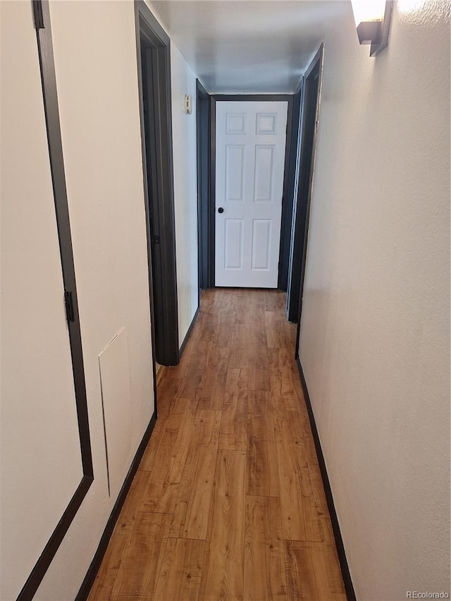 corridor with light hardwood / wood-style floors