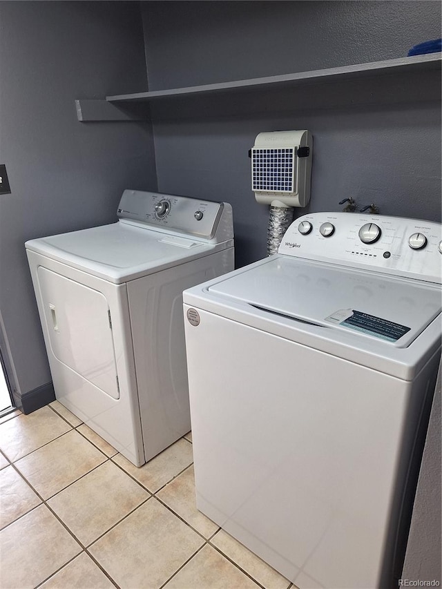 laundry room featuring independent washer and dryer and light tile patterned floors