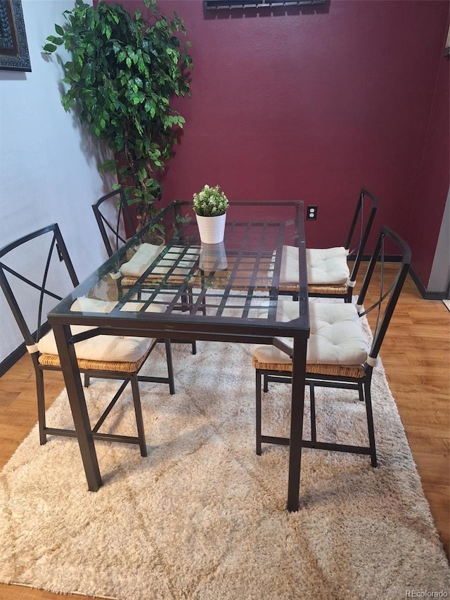 unfurnished dining area featuring baseboards and wood finished floors