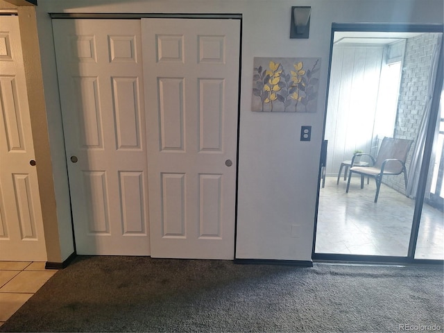 3550 S Harlan St Unit 313, Denver, CO 80235 - unfurnished bedroom featuring tile patterned floors, carpet floors, a closet, and baseboards