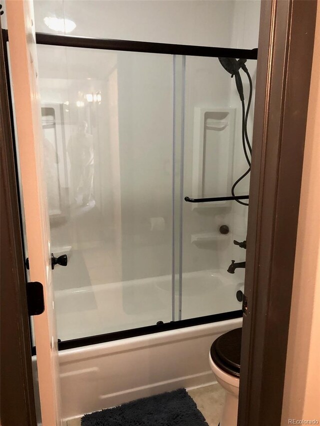 3550 S Harlan St Unit 313, Denver, CO 80235 - full bath featuring shower / bath combination with glass door, toilet, and tile patterned floors