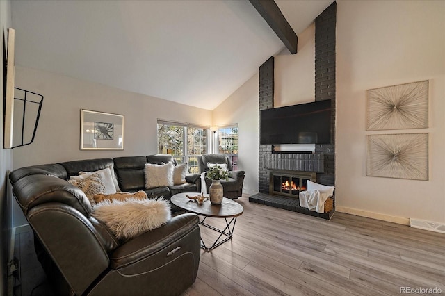 living room featuring visible vents, wood finished floors, a brick fireplace, high vaulted ceiling, and beam ceiling