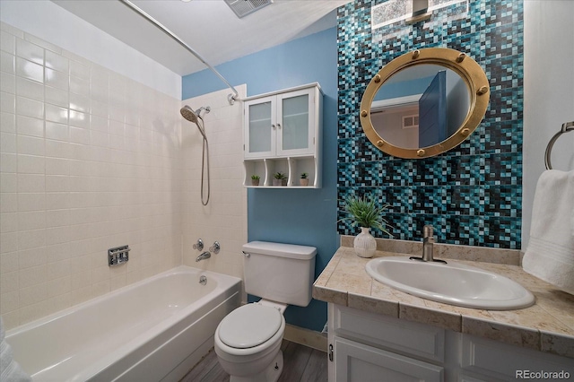 bathroom with bathing tub / shower combination, visible vents, toilet, vanity, and wood finished floors