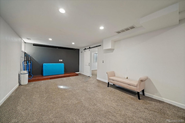 unfurnished room featuring a barn door, visible vents, baseboards, carpet, and recessed lighting