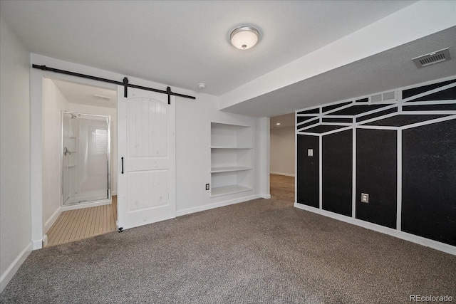 interior space featuring built in features, visible vents, baseboards, and a barn door