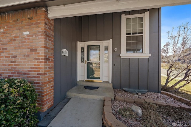 entrance to property featuring board and batten siding and brick siding