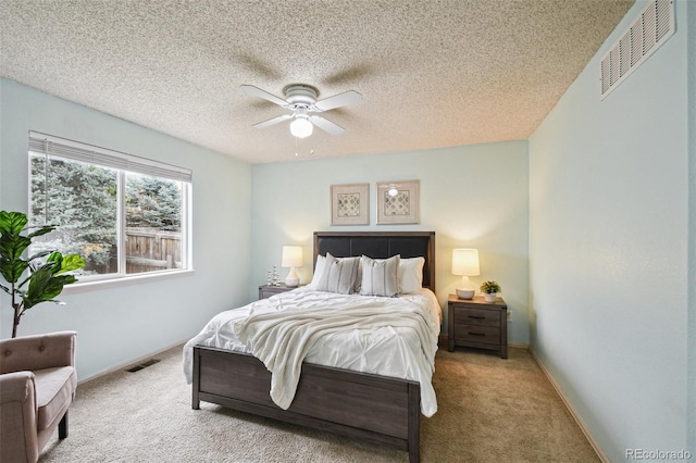 bedroom with a textured ceiling, light colored carpet, and ceiling fan