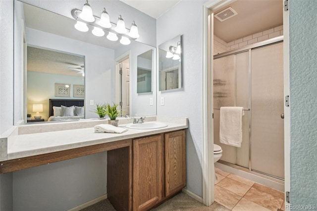 bathroom with a shower with door, vanity, ceiling fan, and toilet