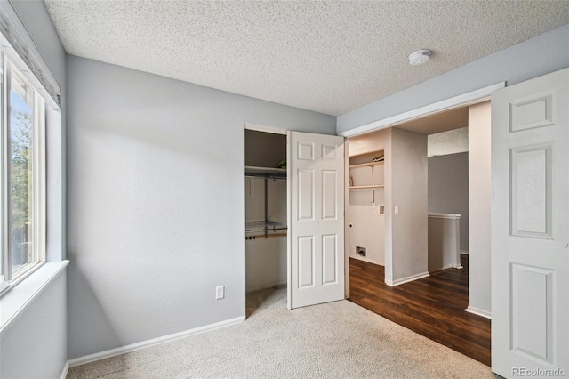 unfurnished bedroom featuring dark carpet and a textured ceiling