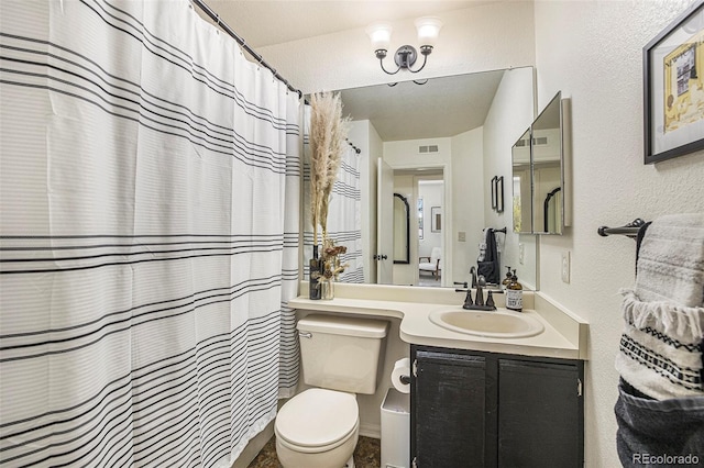 bathroom featuring vanity, curtained shower, and toilet