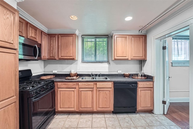 kitchen with black appliances, a sink, dark countertops, healthy amount of natural light, and ornamental molding