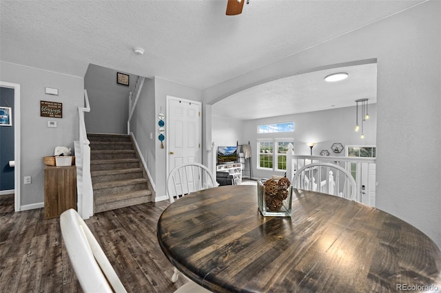 1464 Nemrick Pl, Castle Rock, CO 80109 - dining room featuring dark wood finished floors, baseboards, arched walkways, a textured ceiling, and ceiling fan