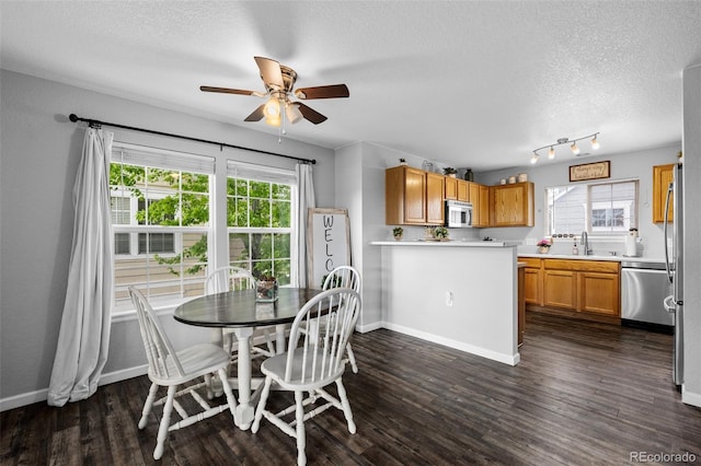 1464 Nemrick Pl, Castle Rock, CO 80109 - dining room with a textured ceiling, healthy amount of natural light, a ceiling fan, dark wood finished floors, and baseboards