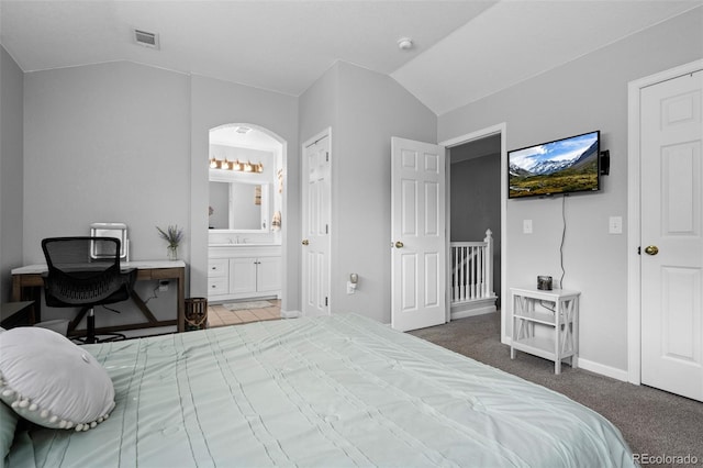1464 Nemrick Pl, Castle Rock, CO 80109 - carpeted bedroom with vaulted ceiling, ensuite bath, baseboards, arched walkways, and a sink