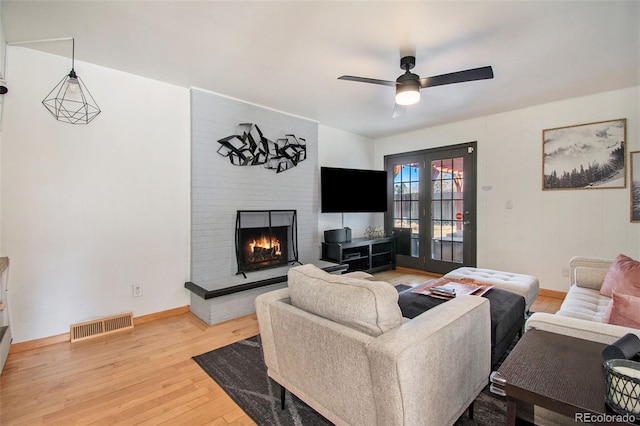 8895 E Radcliff Ave E, Denver, CO 80237 - living area with wood finished floors, ceiling fan, french doors, a large fireplace, and baseboards