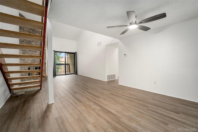 unfurnished living room with lofted ceiling, a textured ceiling, wood-type flooring, and ceiling fan