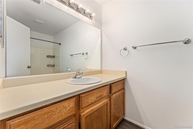 bathroom featuring vanity and tiled shower