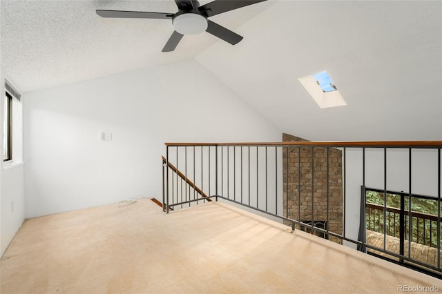 bonus room featuring vaulted ceiling with skylight, carpet flooring, and ceiling fan