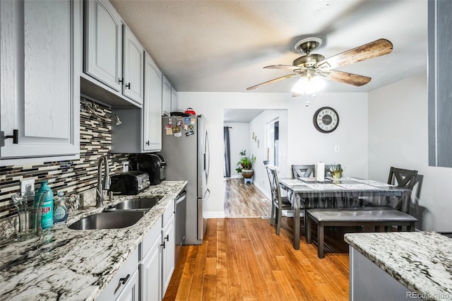327 N 12th Ave, Brighton, CO 80601 - kitchen with a ceiling fan, backsplash, light wood finished floors, and light stone countertops