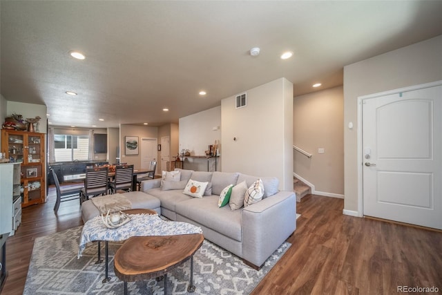 living room with stairs, dark wood-style floors, visible vents, and recessed lighting