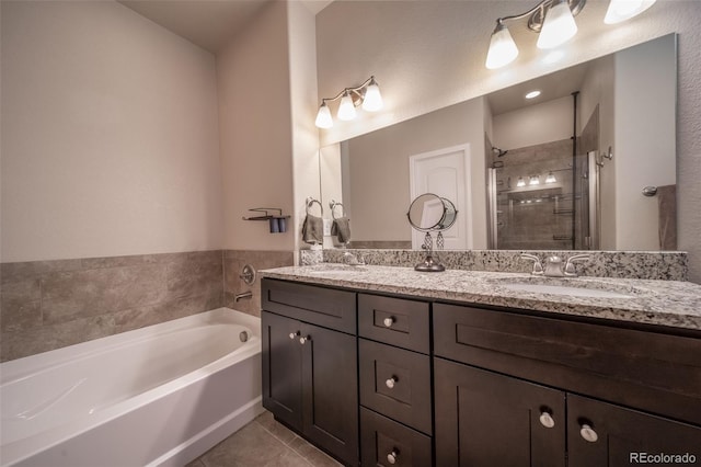 bathroom with a garden tub, double vanity, tile patterned flooring, and a sink