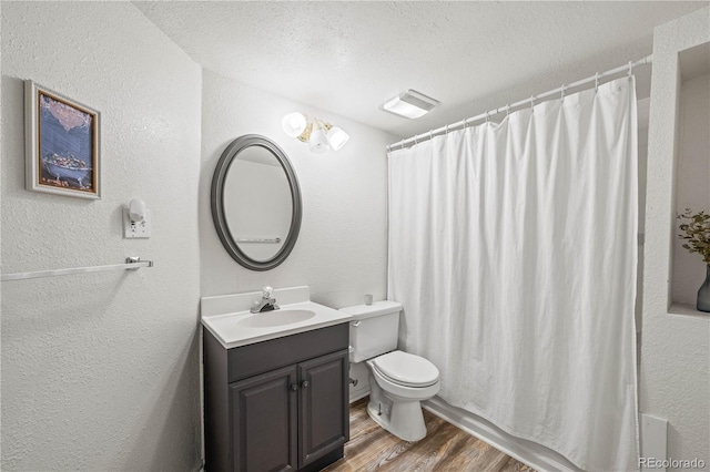 6808 Silverleaf Ave, Firestone, CO 80504 - bathroom featuring wood finished floors, vanity, a textured wall, a textured ceiling, and a shower with shower curtain