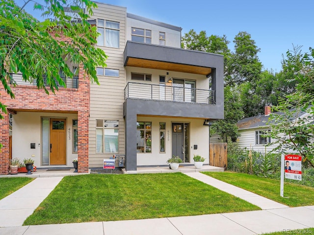 4535 Stuart St, Denver, CO 80212 - view of front facade featuring a balcony, a front lawn, and stucco siding